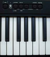 avvicinamento di pianoforte chiavi. pianoforte nero e bianca chiavi e pianoforte tastiera musicale strumento posto a il casa balcone durante soleggiato giorno. foto