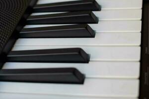 avvicinamento di pianoforte chiavi. pianoforte nero e bianca chiavi e pianoforte tastiera musicale strumento posto a il casa balcone durante soleggiato giorno. foto