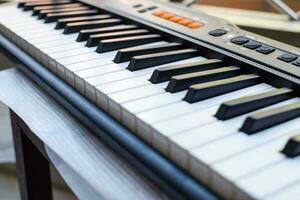 avvicinamento di pianoforte chiavi. pianoforte nero e bianca chiavi e pianoforte tastiera musicale strumento posto a il casa balcone durante soleggiato giorno. foto