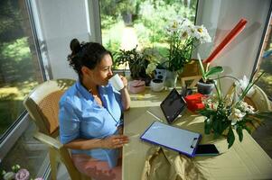 incinta donna, femmina illustratore assunzione un' rompere per caffè mentre Lavorando su creativo compito su toccare tampone digitale tavoletta foto