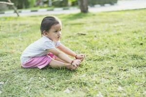 bambino fare esercizio su piattaforma all'aperto. salutare stile di vita. yoga ragazza foto