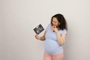 bellissimo incinta donna esprimendo positivo emozioni, Tenere il bambino ecografia. gravidanza ostetricia ginecologia foto