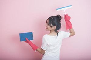 bella casalinga asiatica sorridente su sfondo rosa foto