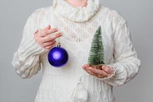 la donna tiene un albero di natale e un ornamento foto