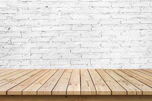 piano del tavolo in legno vuoto su sfondo bianco muro di mattoni, utilizzato per visualizzare o montare i tuoi prodotti foto