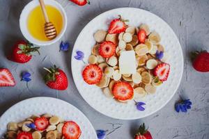 cereali per pancake, cibo alla moda. mini pancake ai cereali con burro, miele e fragole. foto