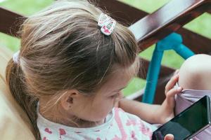 giovane bambino in età prescolare che utilizza lo smartphone bambini che utilizzano la tecnologia digitale foto
