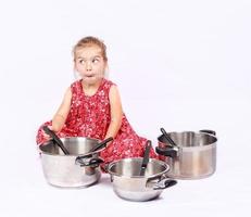 bambino che usa gli accessori della cucina divertendosi foto