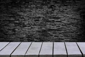 il tavolo vuoto lo sfondo è un muro di mattoni vuoto ripiani in legno e un muro di pietra sullo sfondo foto