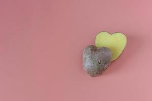 patate a forma di cuore tagliate a metà su uno sfondo rosa. concetto di agricoltura, raccolta, vegetarianismo