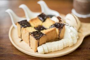 toast al miele con gelato alla vaniglia, panna montata e sciroppo di cioccolato. servito con banana