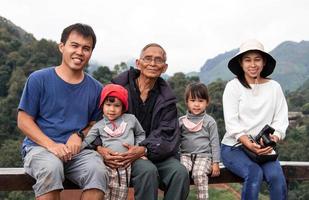 una famiglia asiatica felicemente fotografata insieme in una piantagione di tè. foto