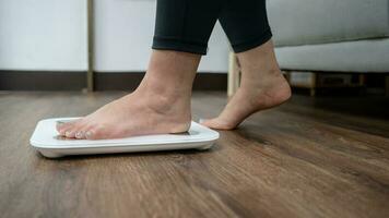 Grasso dieta e scala piedi in piedi su elettronico bilancia per peso controllo. misurazione strumento nel chilogrammo per un' dieta controllo. foto