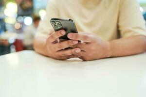 rilassato giovane asiatico uomo utilizzando inteligente Telefono la spesa tempo controllo notizia sociale media. foto