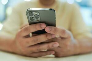 rilassato giovane asiatico uomo utilizzando inteligente Telefono la spesa tempo controllo notizia sociale media. foto