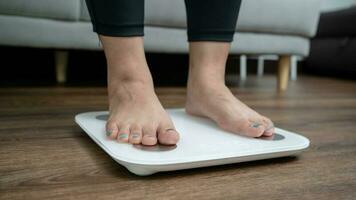 piedi in piedi su elettronico bilancia per peso controllo. misurazione strumento nel chilogrammo per un' dieta controllo foto