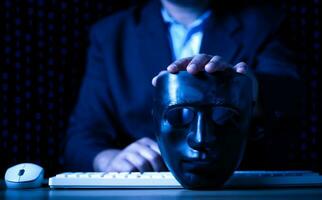 pirateria e il malware concetto, pirata utilizzando astratto il computer portatile con binario codice digitale interfaccia, uomo Tenere un' nero maschera. foto