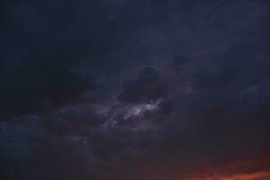 tempestoso tramonto. luminosa rosso e blu nuvole e il ambientazione sole. foto