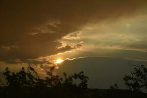 tempestoso tramonto. giallo-blu nuvole e il ambientazione sole. foto