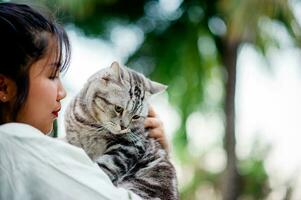 donna Tenere gatto giocando a casa con amore per gatti il Sorridi riflessi nel il suo legame con il suo soffice animale domestico gatto. il relazione di persone e gatti, gatto proprietari, domestico gatti, Grasso gatti foto