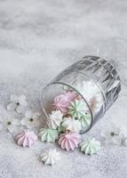piccole meringhe bianche, rosa e verdi nel bicchiere foto