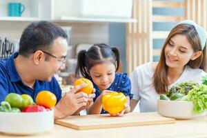 contento asiatico famiglia concetti, padre madre e figlia cucinando insieme nel il cucina foto