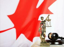 statua di themis e giudici martelletto su un' libro. bandiera di Canada nel il sfondo. foto
