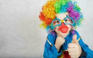 ragazzo di cinque anni vestito nel il costume di un' clown e divertente occhiali con rosso naso. foto