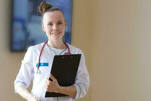 un' giovane sorridente medico vestito nel un' bianca professionale uniforme foto