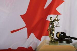 statua di themis e giudici martelletto su un' libro. bandiera di Canada nel il sfondo. foto