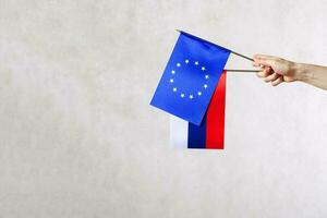 un' mano con Due bandiere - Unione Europea e Russia foto
