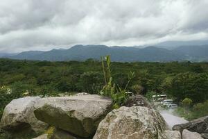 enorme rocce con lussureggiante verde paesaggio e montagna sotto nuvoloso cielo a costa rica foto