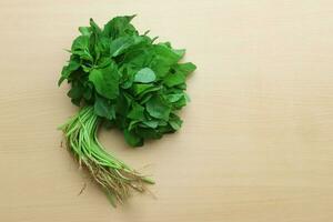 spinaci, fresco verde spinaci isolato su di legno sfondo foto