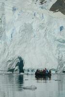turisti Guardando un' ghiacciaio nel Antartide, vicino il antartico penisola. foto