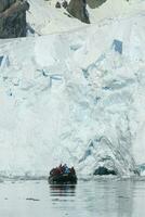 turisti Guardando un' ghiacciaio nel Antartide, vicino il antartico penisola. foto