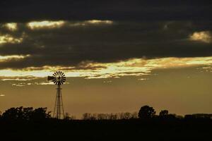 paesaggio con mulino a vento a tramonto, pampa, Patagonia, Argentina foto