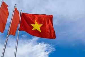 Vietnam bandiera isolato su il blu cielo con ritaglio sentiero. vicino su agitando bandiera di Vietnam. foto
