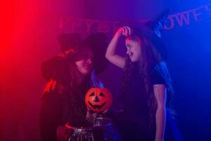 divertente bambino ragazza e donna nel streghe costumi per Halloween con zucca Jack. foto