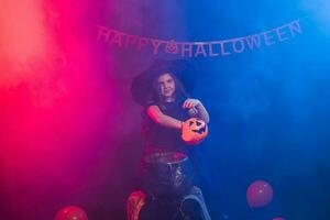 poco strega bambino cucinando pozione nel il calderone su Halloween. foto