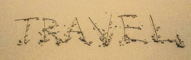 scritto parole viaggio su sabbia di spiaggia nel estate giorno foto