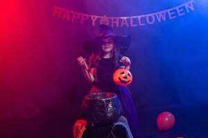 divertente bambino ragazza nel strega costume per Halloween con zucca Jack. foto