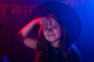 divertente bambino ragazza nel strega costume per Halloween con ragno. foto