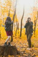 madre assunzione immagine sua carismatico figlia su retrò telecamera nel autunno parco. Hobby e tempo libero concetto. foto