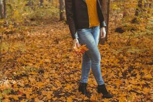 avvicinamento di donna è calciando giallo le foglie nel autunno. triste umore e di stagione affettivo disturbo concetto. foto