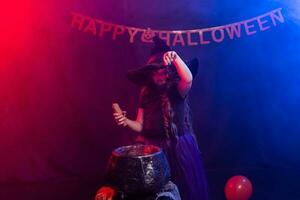 divertente bambino ragazza nel strega costume per Halloween con zucca Jack. foto