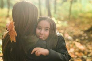 madre e sua poco figlia nel autunno parco nel autunno stagione. foto