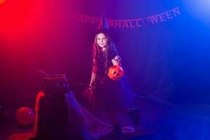 divertente bambino ragazza nel strega costume per Halloween con zucca Jack. foto