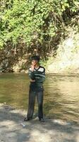 gorontalo-indonesia, jan 2023 - giovane uomo godendo il mattina atmosfera di il sul fiume foto