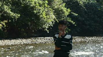 gorontalo-indonesia, jan 2023 - giovane uomo godendo il mattina atmosfera di il sul fiume foto