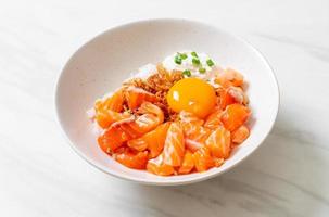 riso giapponese con salmone fresco crudo e uova foto